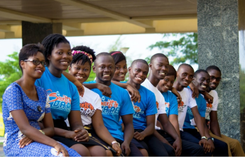 a group of 11 people wearing blue shirts looking at the camera and smiling