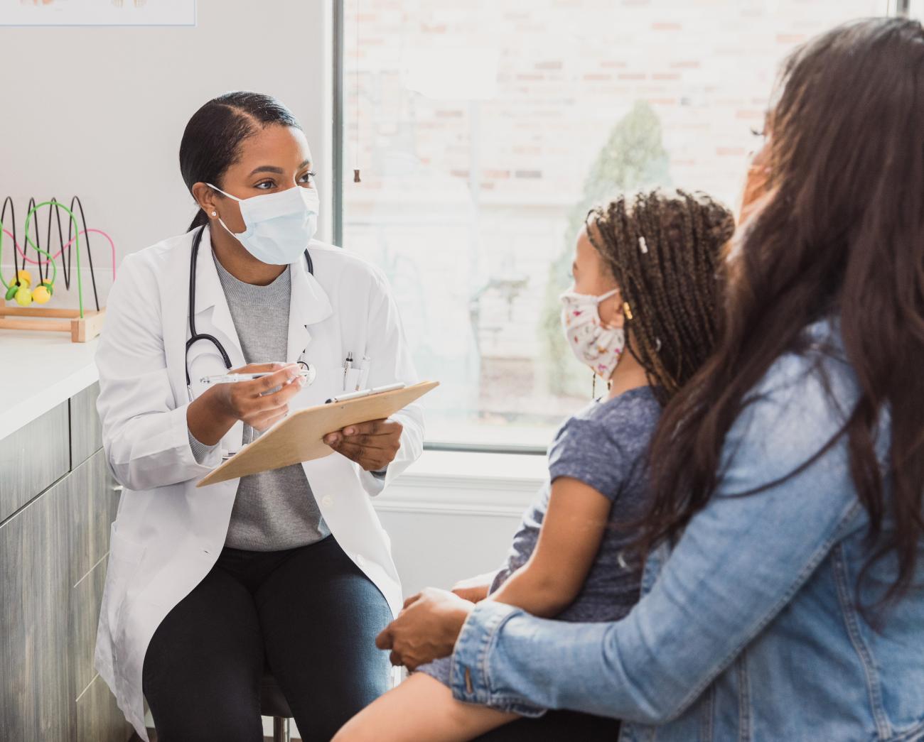 Mother and child consulting with doctor